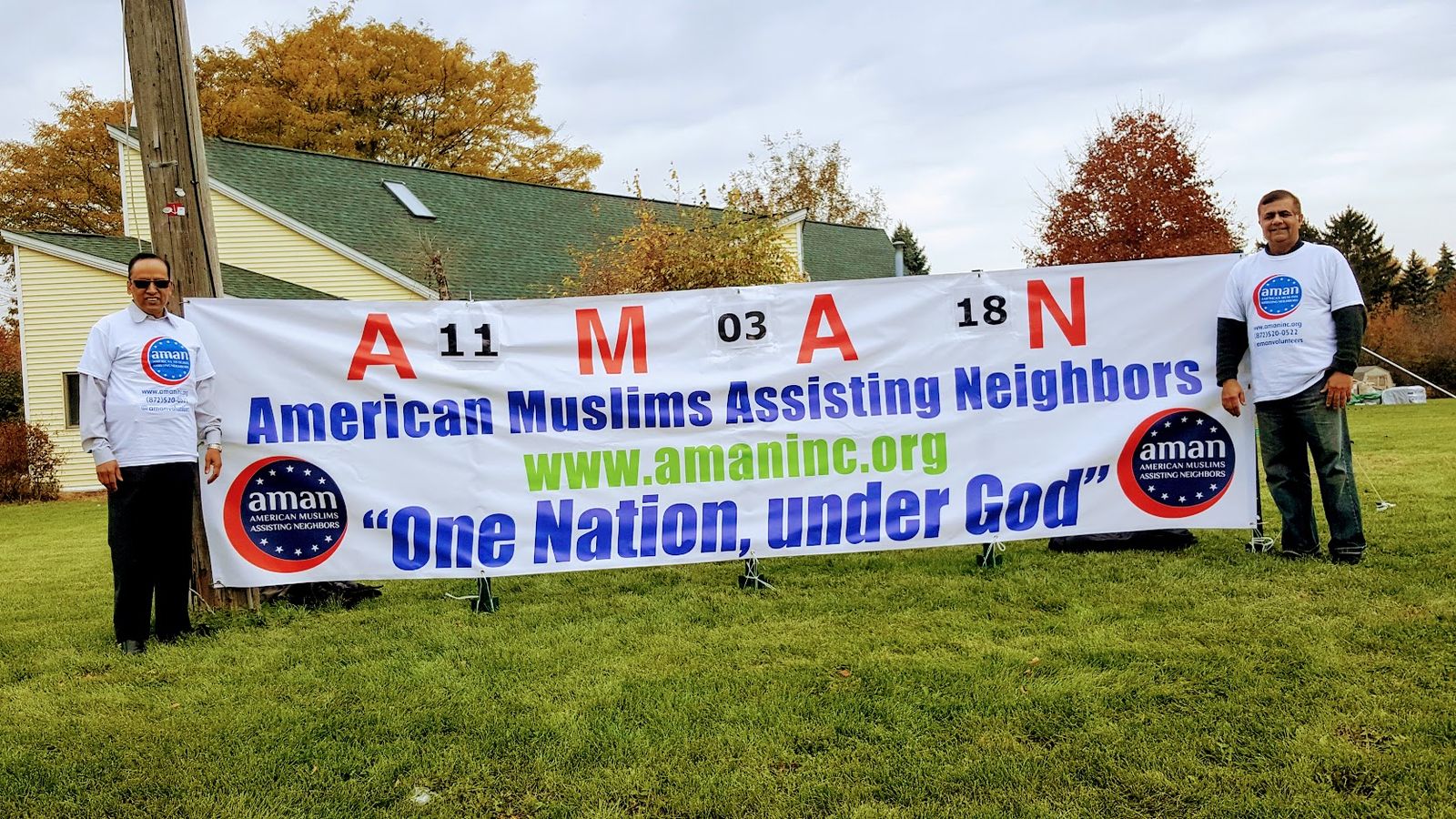AMAN volunteers with the One Nation, Under God banner at a community event