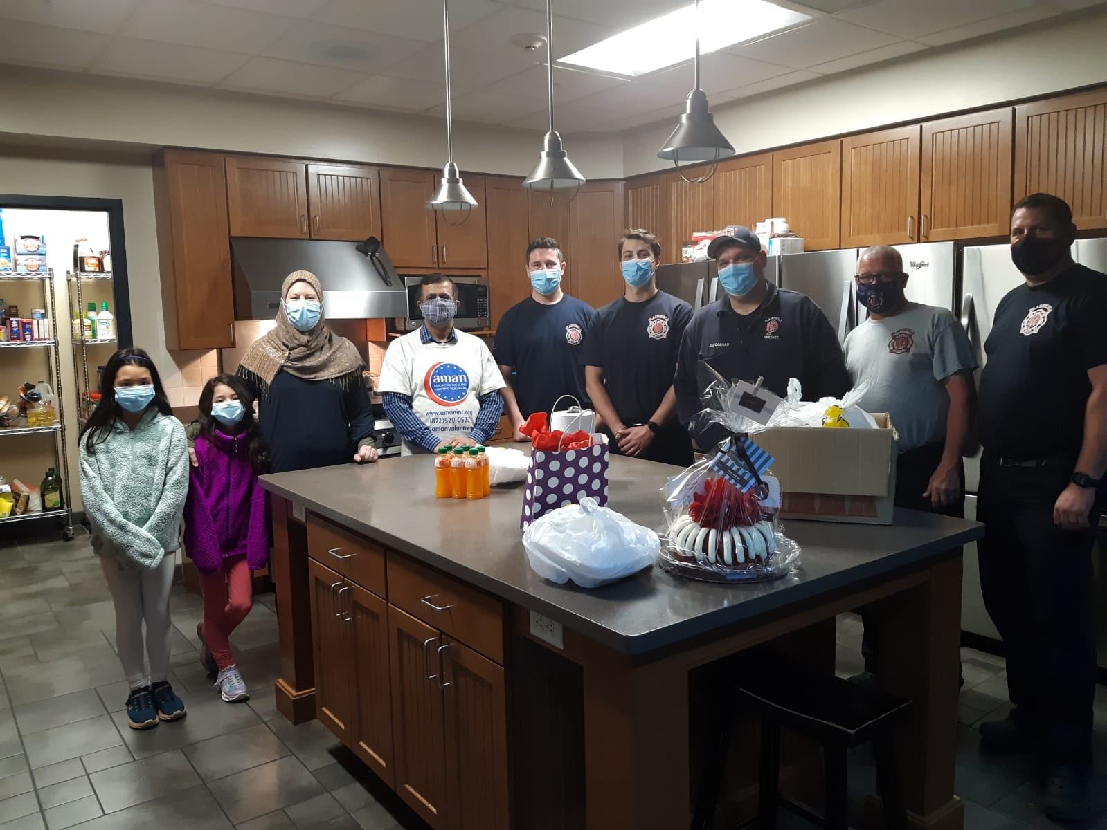 AMAN volunteers and families with gift baskets at a Plainfield fire station