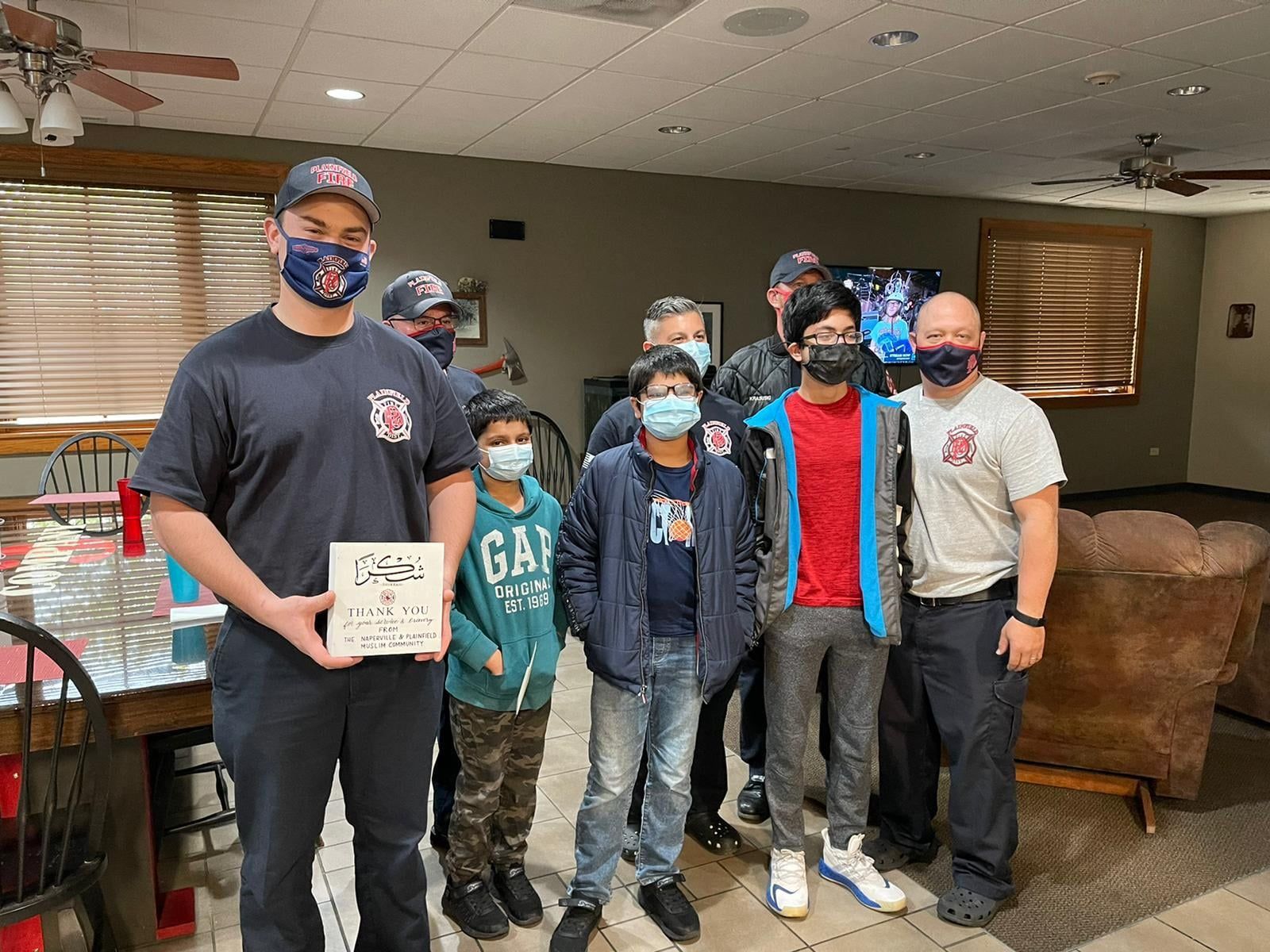 AMAN volunteers presenting a thank-you plaque to Plainfield firefighters