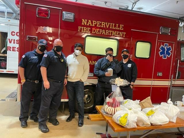 AMAN volunteers with bags of food in front of a Plainfield fire engine