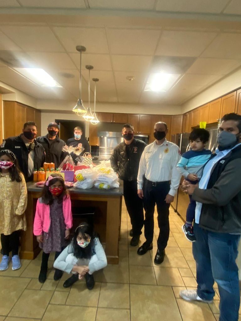 AMAN volunteers and children delivering gift bags at a Plainfield fire station